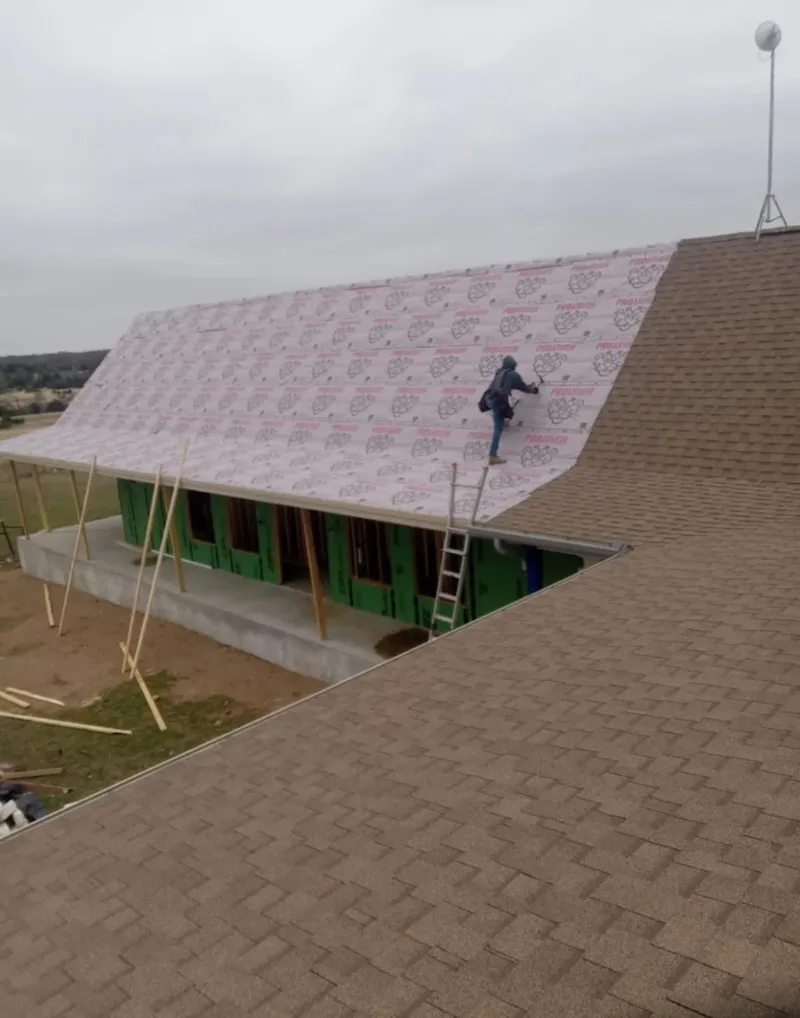 Worker preparing underlayment for a metal roof installation in Union City